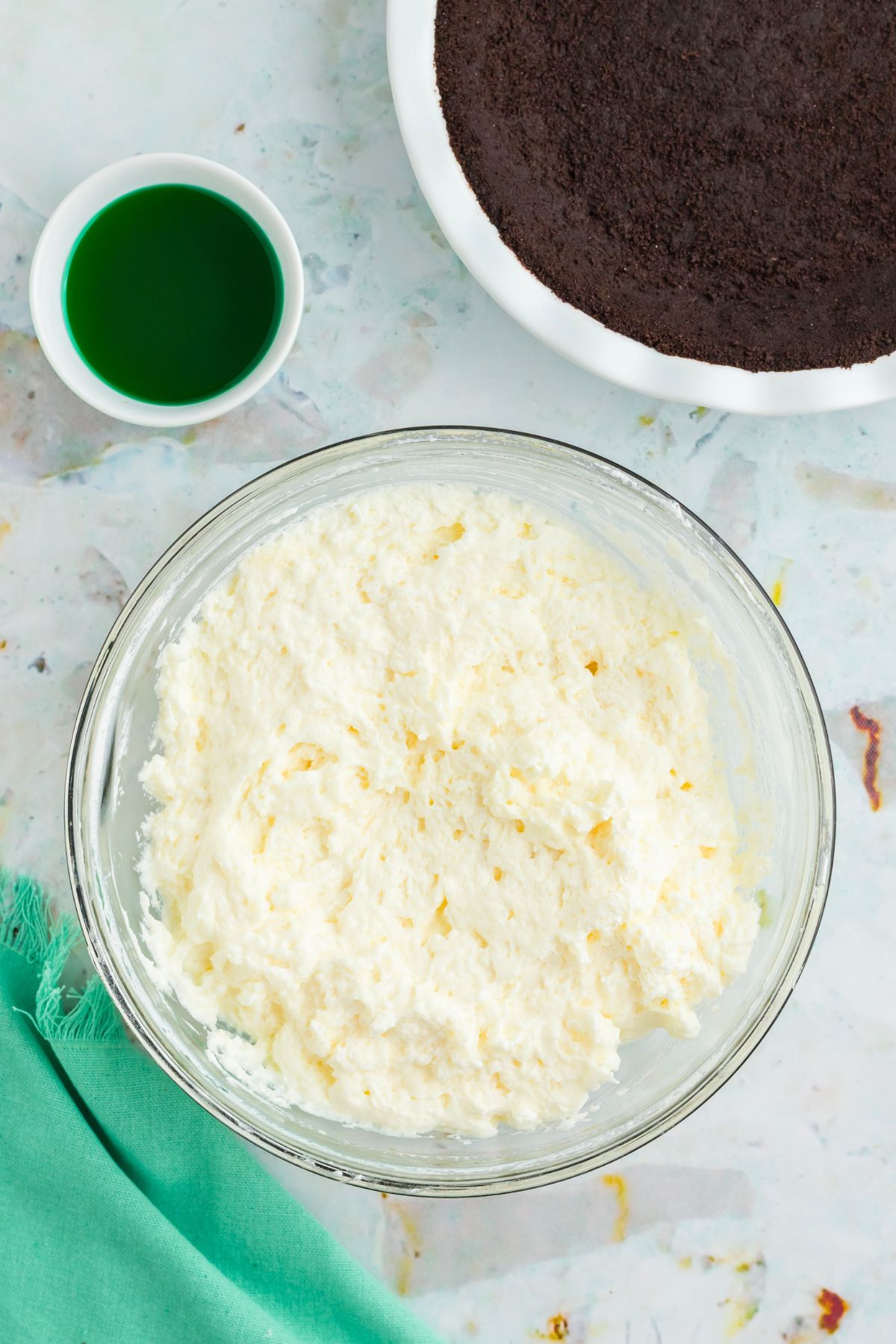 Heavy cream whipped into  a stiff cream in a clear glass bowl. 