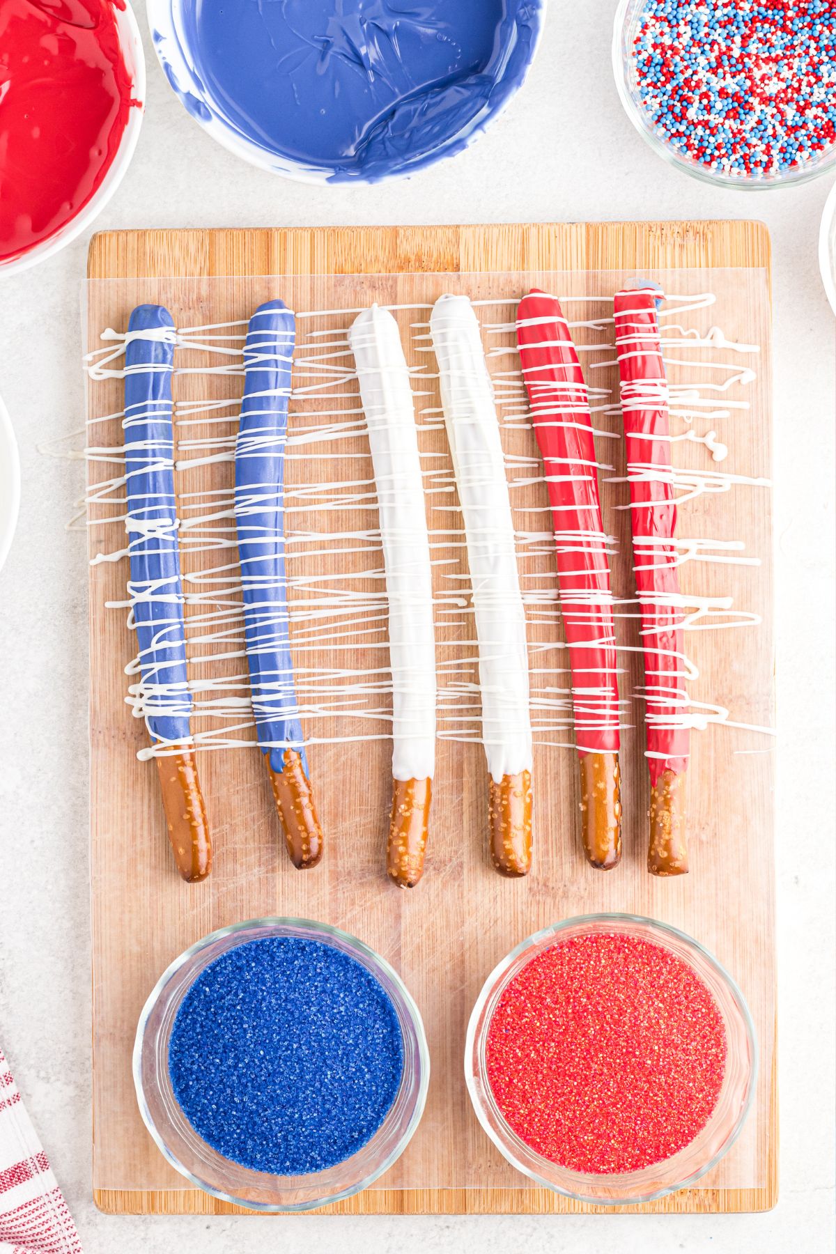 Pretzels dipped in candy melts then drizzled and topped with sprinkles.