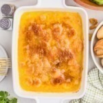 Baked, cheesy shrimp scampi in a white baking dish.