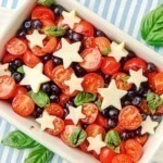 Blueberries, tomatoes, and mozzarella cheese shaped into stars, in a rectangle baking dish.