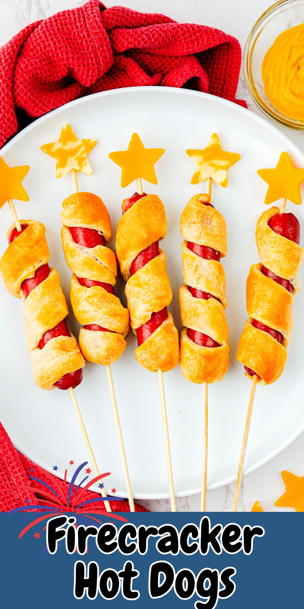 Five hot dogs wrapped in crescent roll dough, baked, and then topped with cheese stars, on a round white plate.