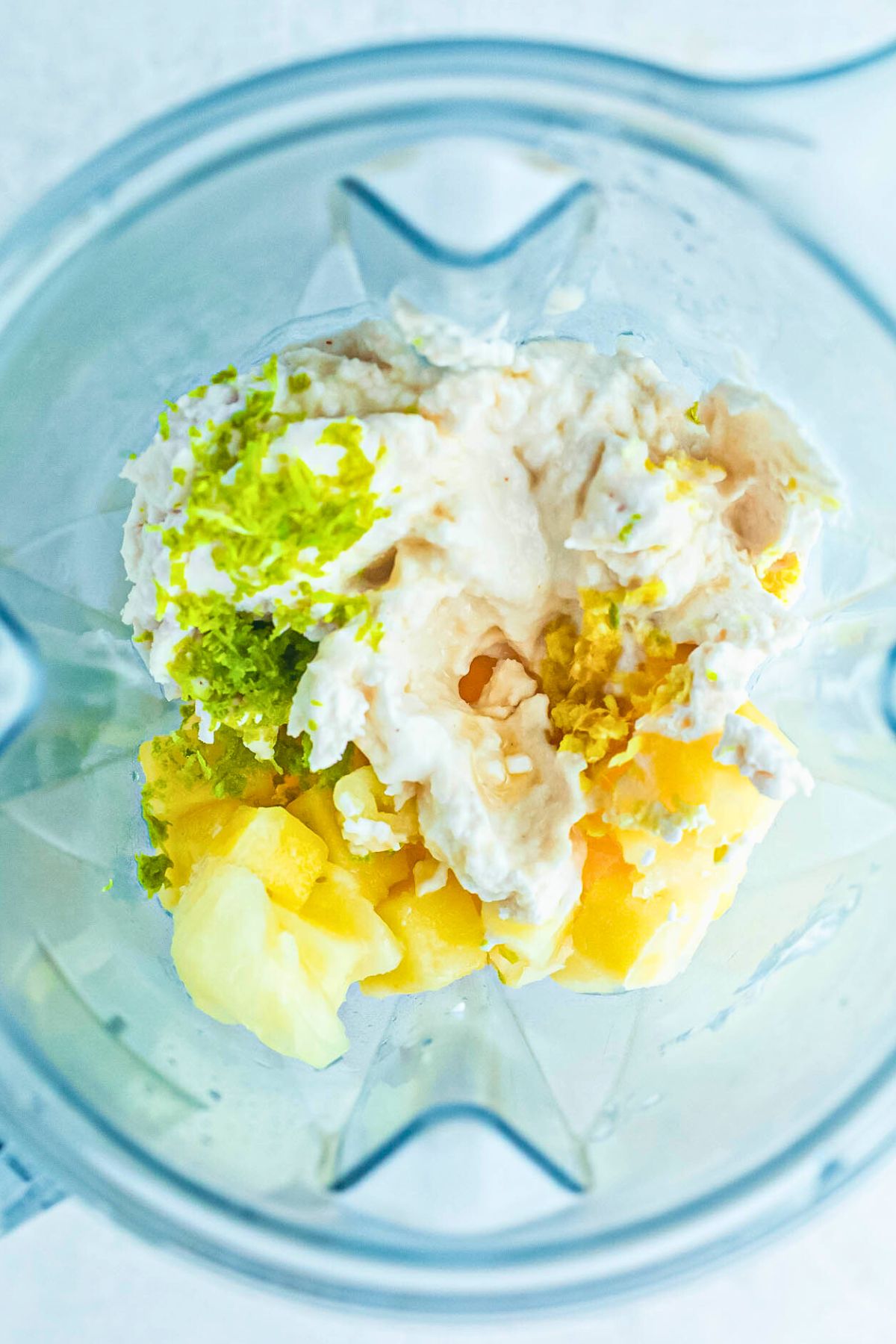 Ingredients needed to make virgin pina coladas in a blender, before mixing. 