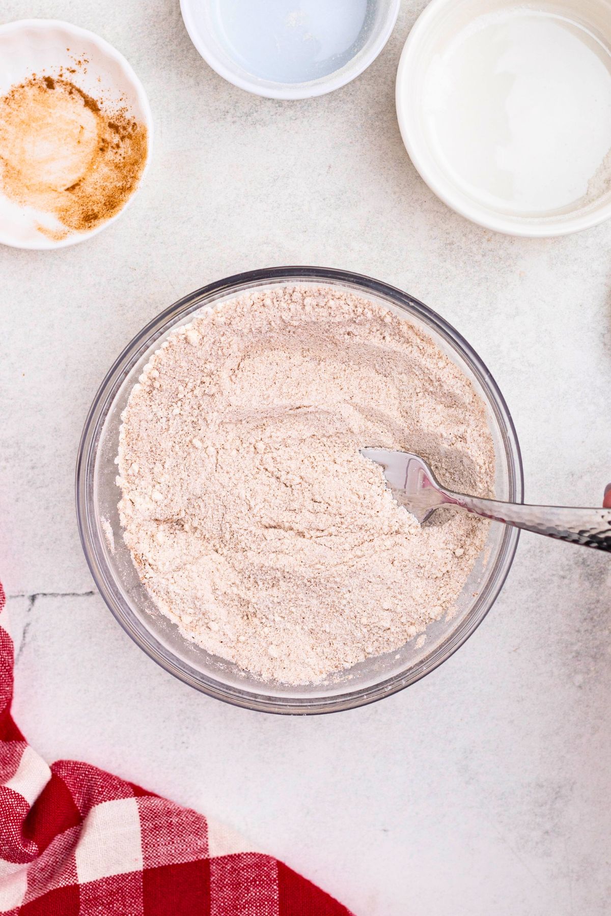 Flour, sugar, cinnamon, and nutmeg, mixed together in a medium bowl. 