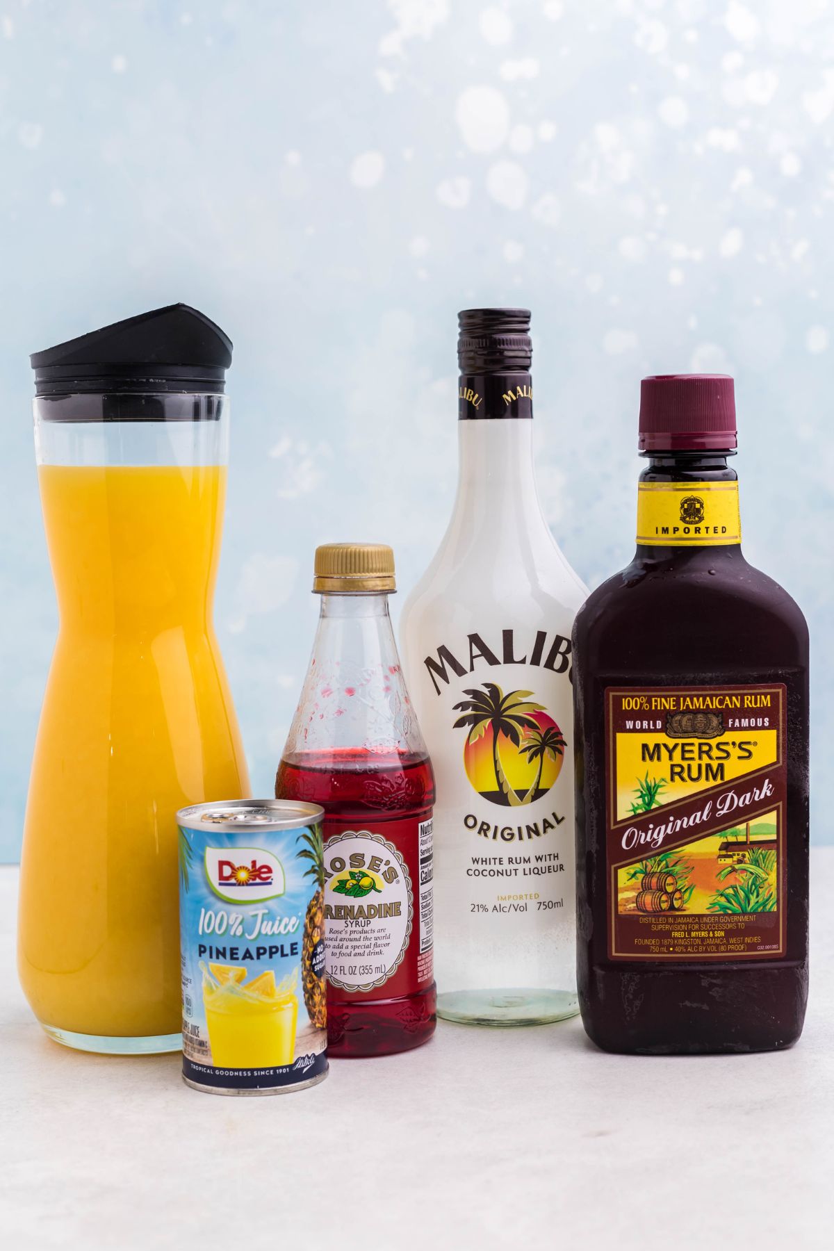 Bottles of alcohol and juices on a marble table. 