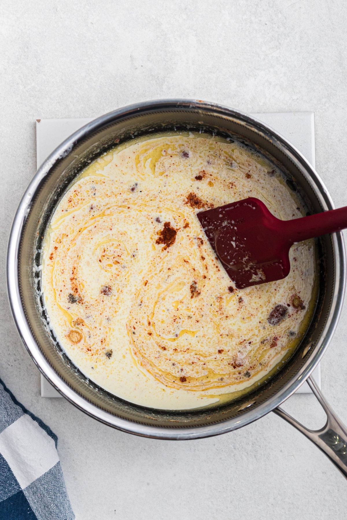 Heavy cream, butter, and seasonings, mixed together in a saucepan.