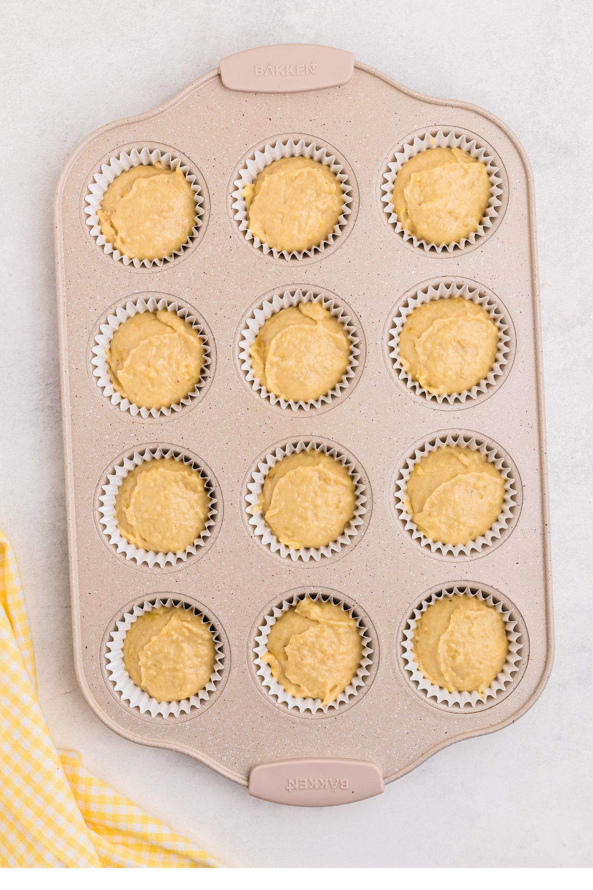 Muffin pan filled with banana bread muffin dough before baking.