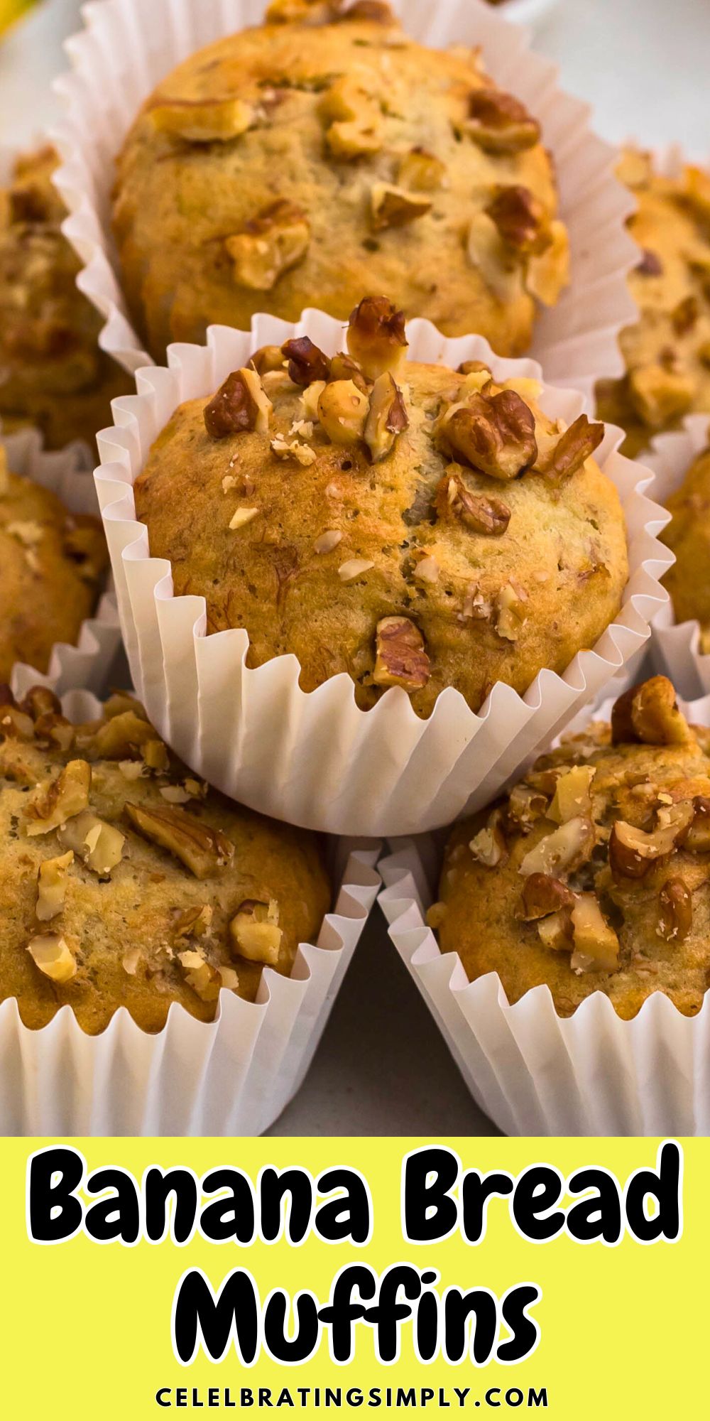 Light golden brown banana bread muffins in white liners, topped with chopped pecans.