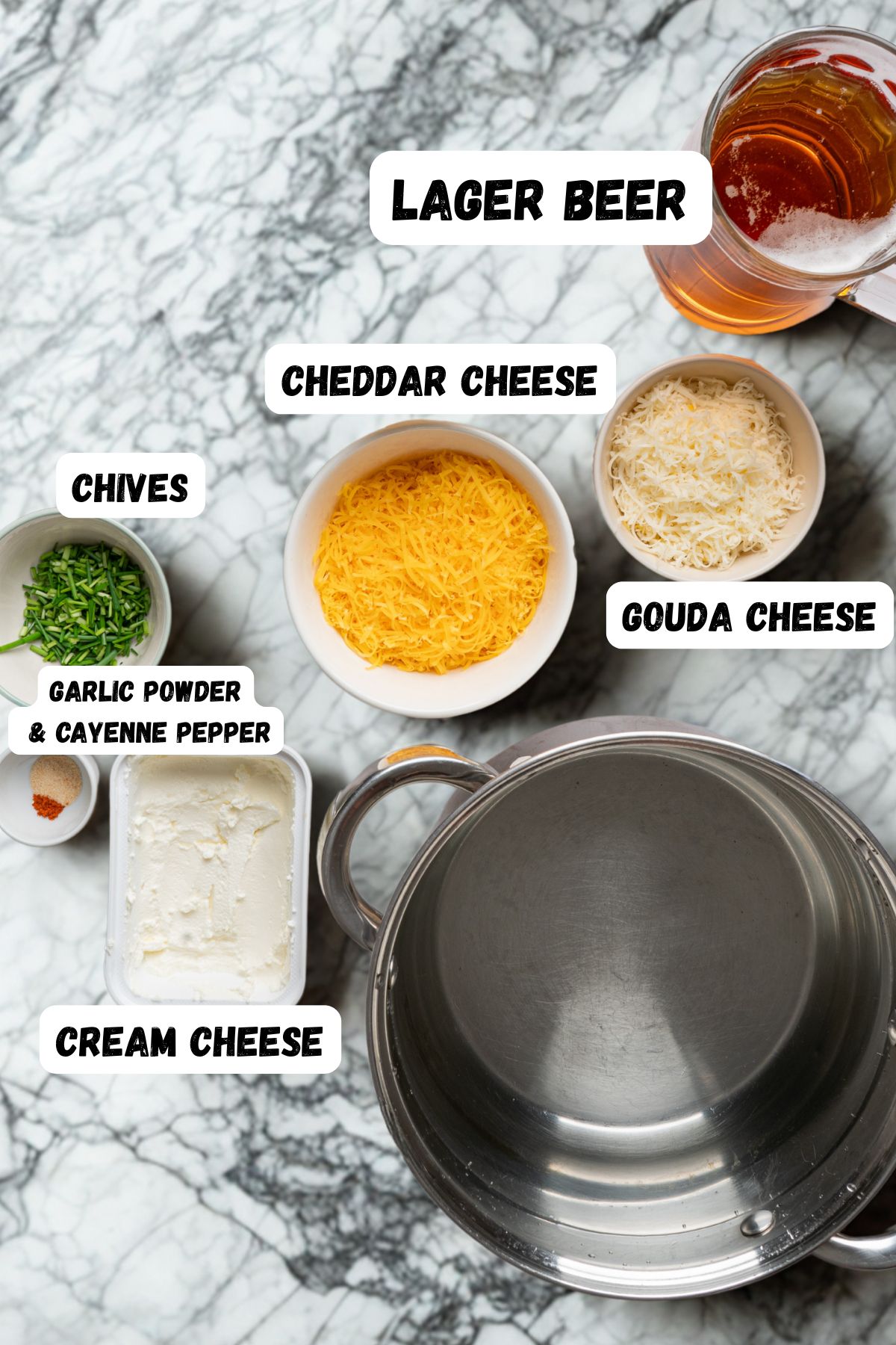 Cream cheese, cheddar and cheese, and seasonings, measured in small bowls on a marble table. 