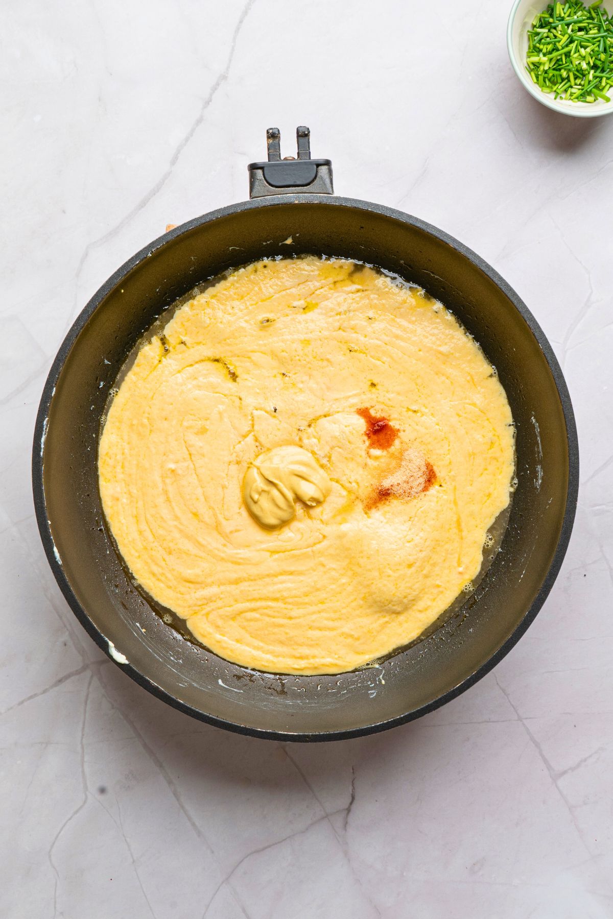 Cheeses mixed with seasonings and beer in a saucepan. 