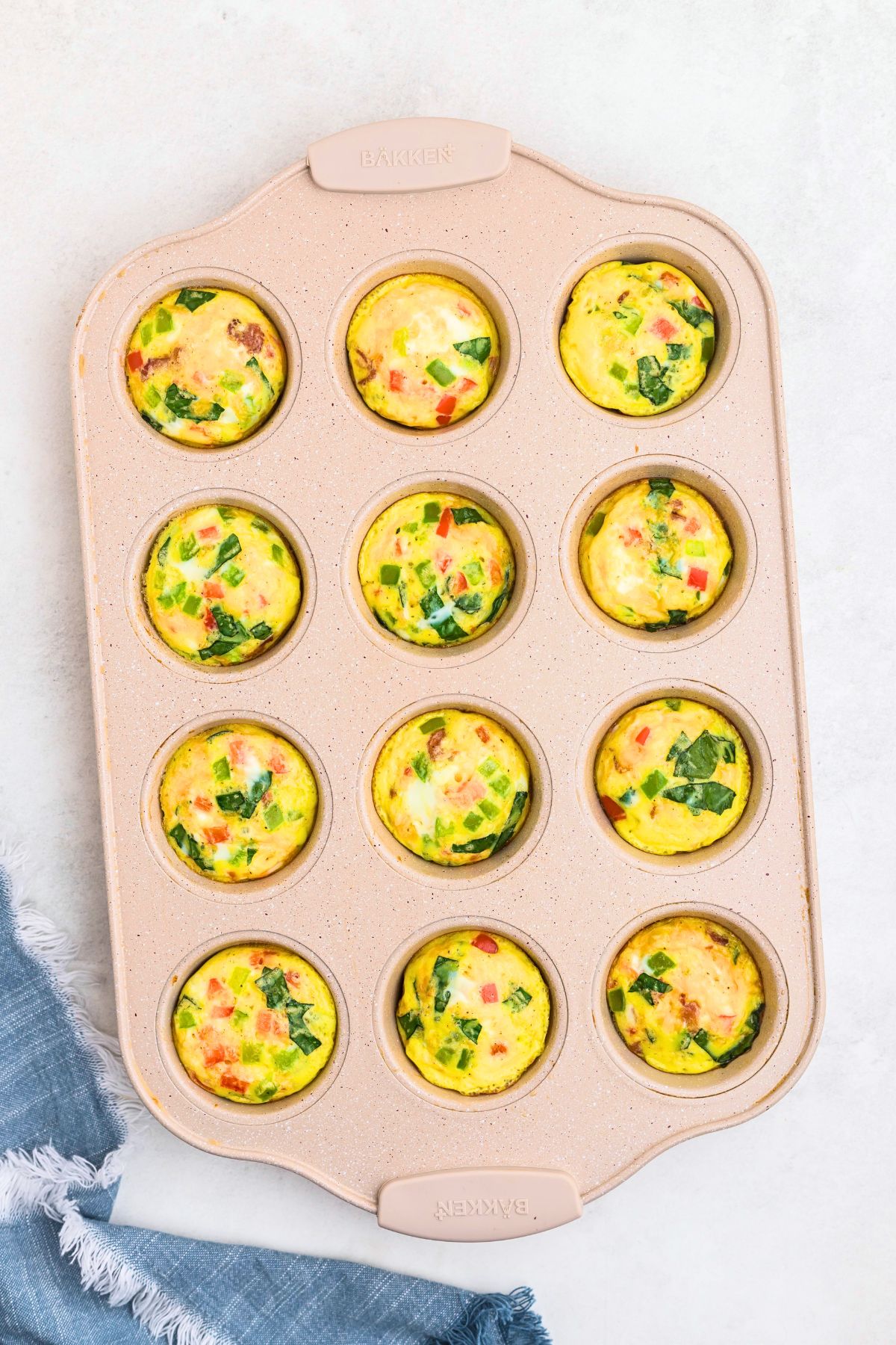 Freshly baked eggs bites in a muffin pan after baking in the oven. 