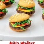 Vanilla wafer hamburger cookies on a white plate.