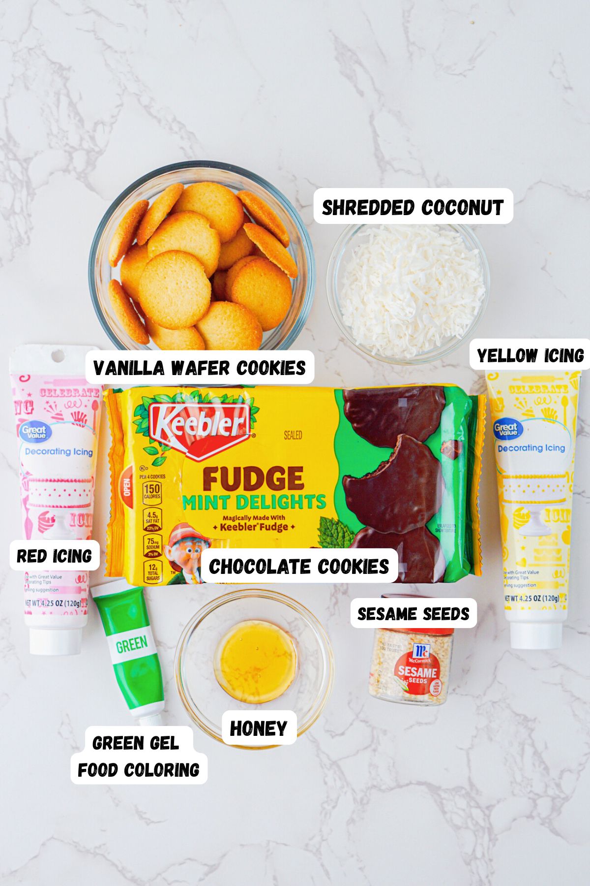 Ingredient photo showing cookies, frosting, and other ingredients, on a white marble table. 