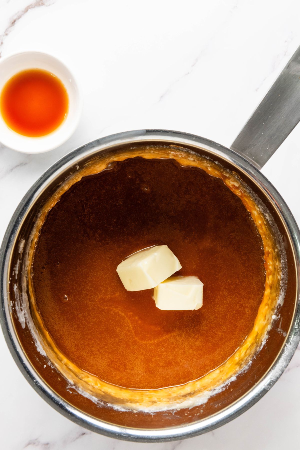Large saucepan with butter being added. 