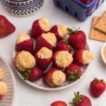Cheesecake stuffed strawberries on a marble table.