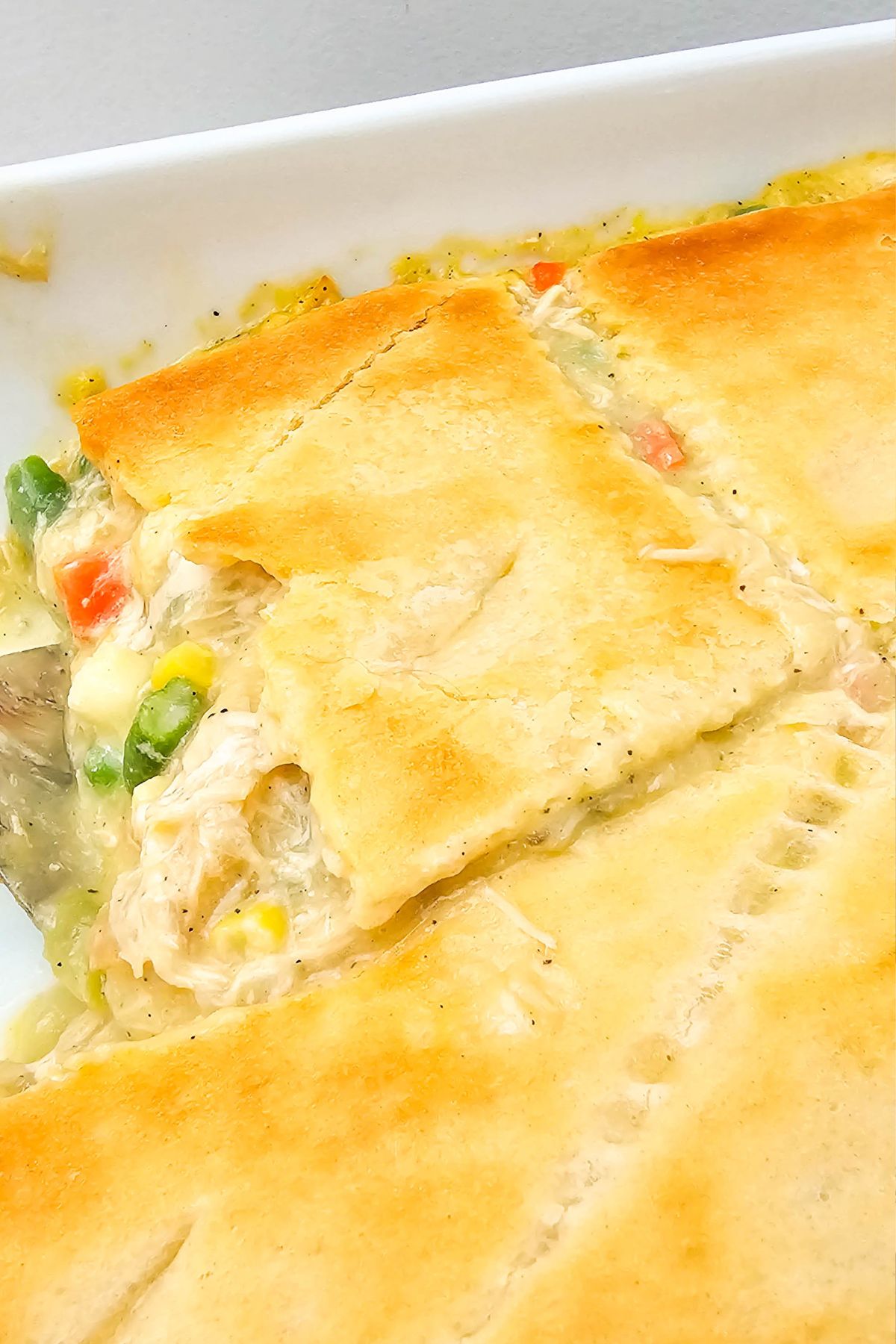 Golden crusted chicken pot pie casserole in baking dish after baking in the oven. 