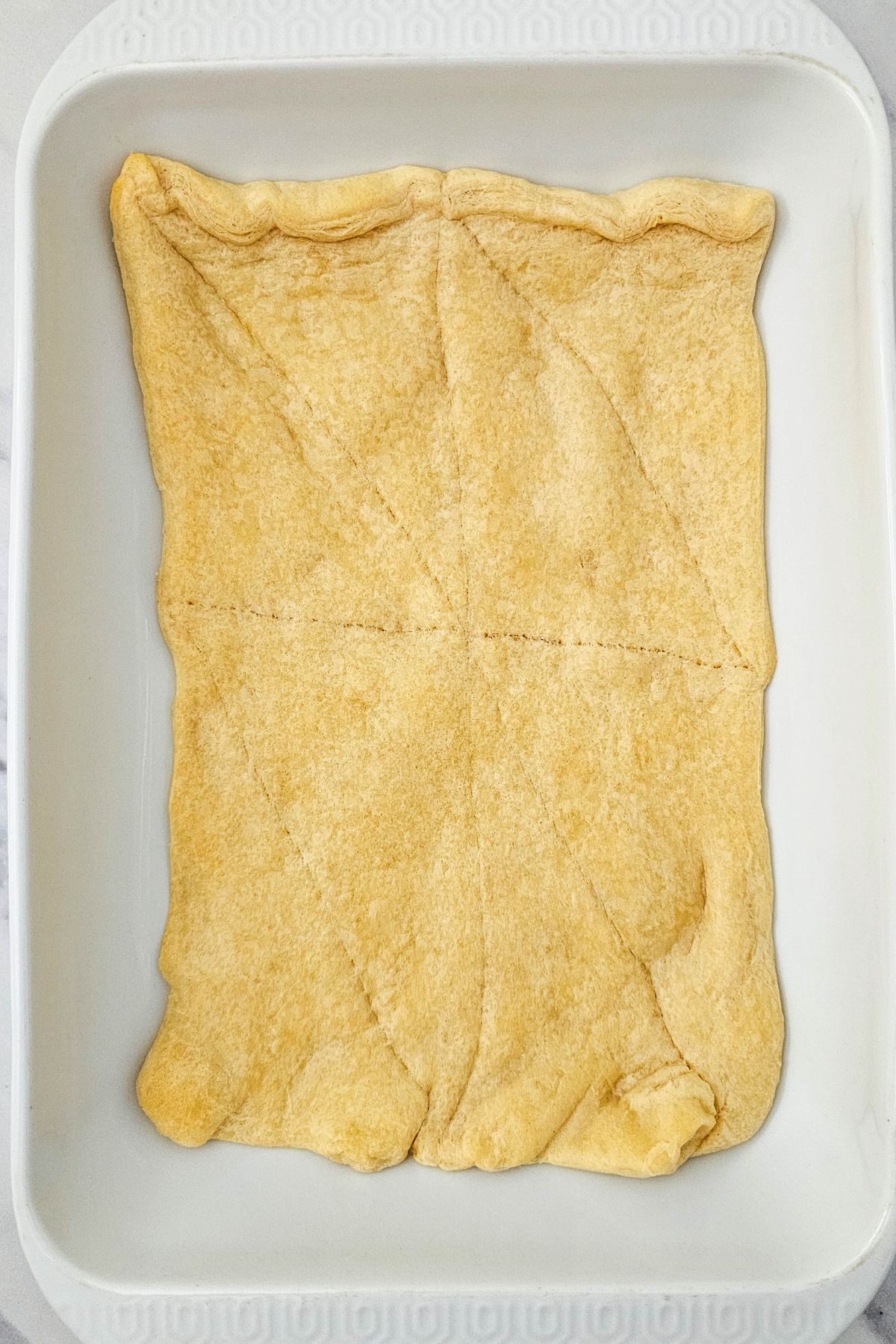 Golden baked crescent roll die in a baking dish. 