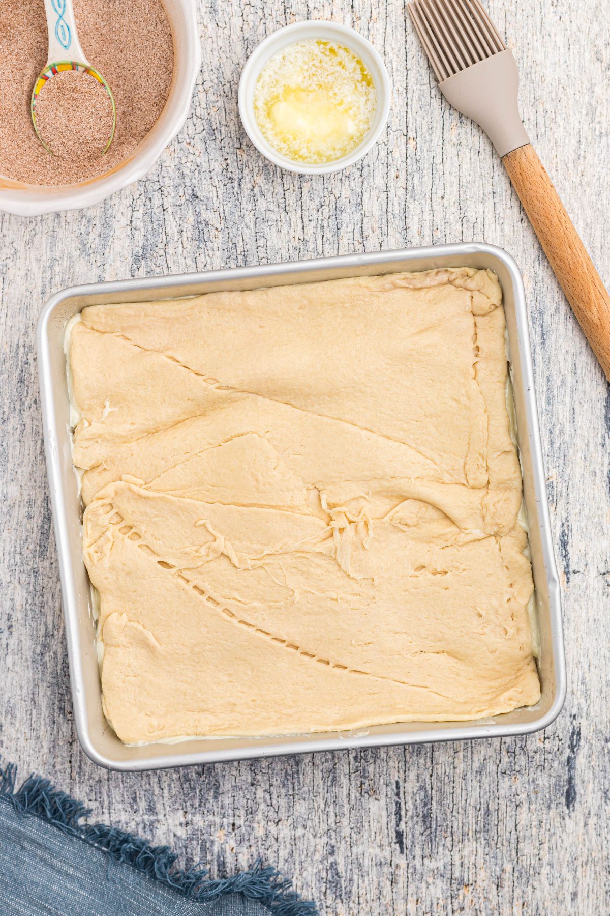 Crescent roll dough rolled out and topping cheesecake filling. 