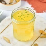 Small jar filled with yellow chicken stock.