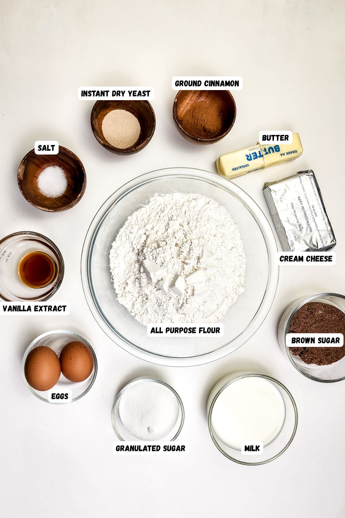 Ingredients measured into small bowls and labeled on a white marble table.
