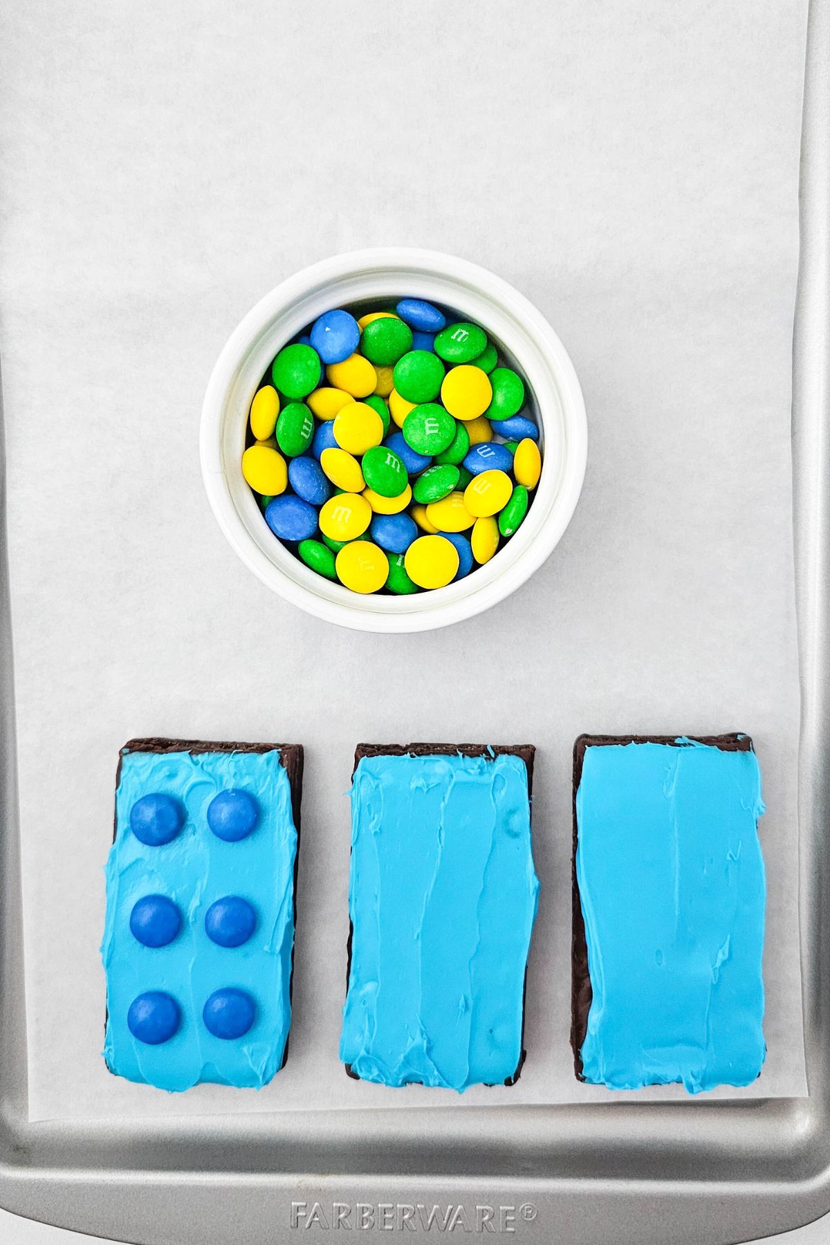 Frosted brownies topped with matching chocolate candies, made to look like Lego bricks. 