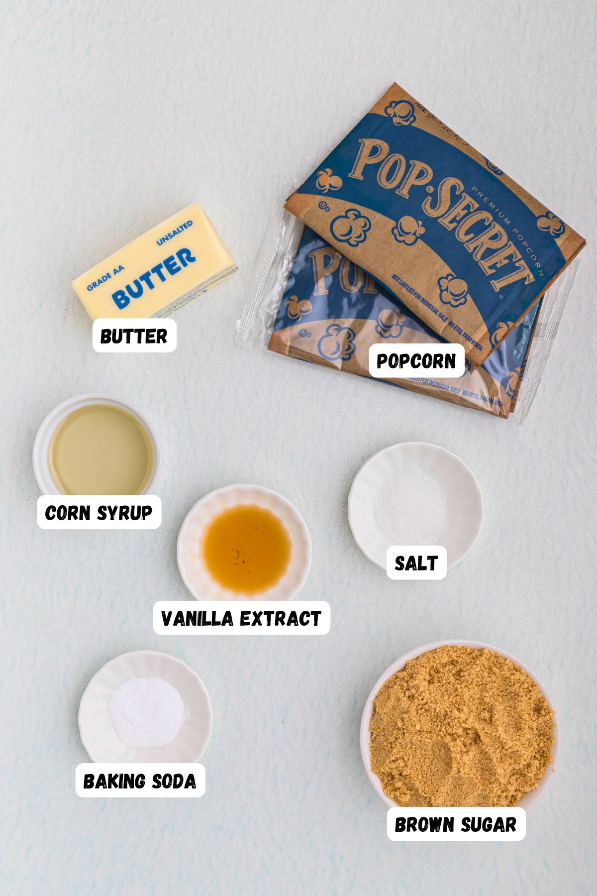 Ingredients measured into small bowls and labeled on a marble table. 