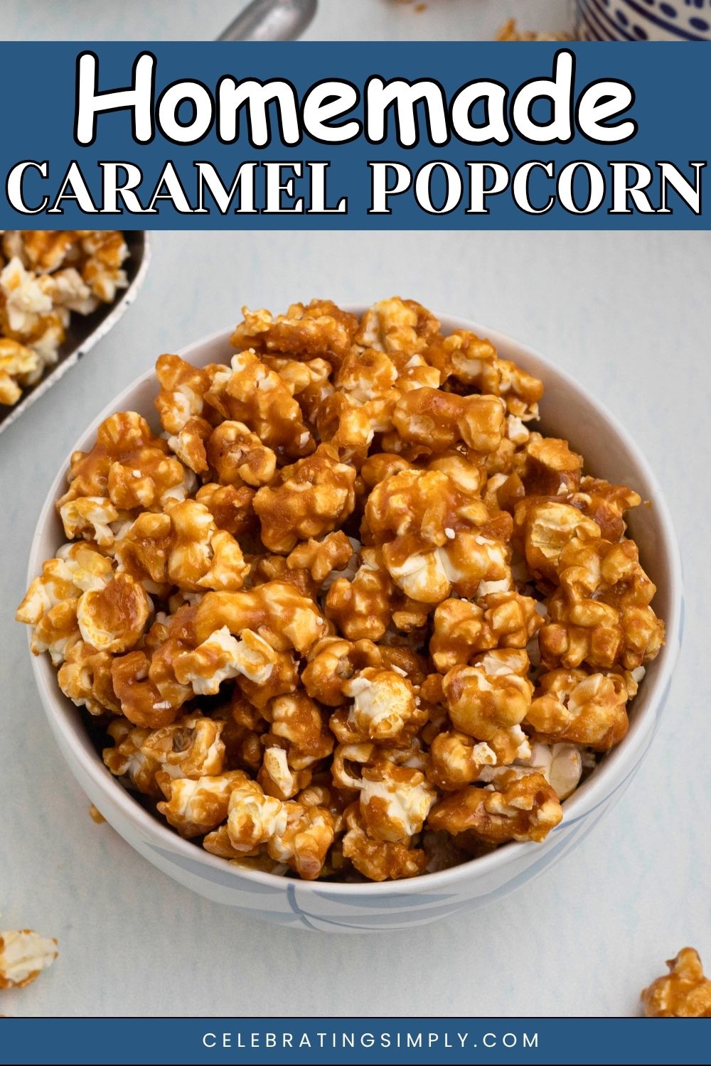Golden caramel popcorn in a white bowl with pieces of popcorn scattered around the bowl.