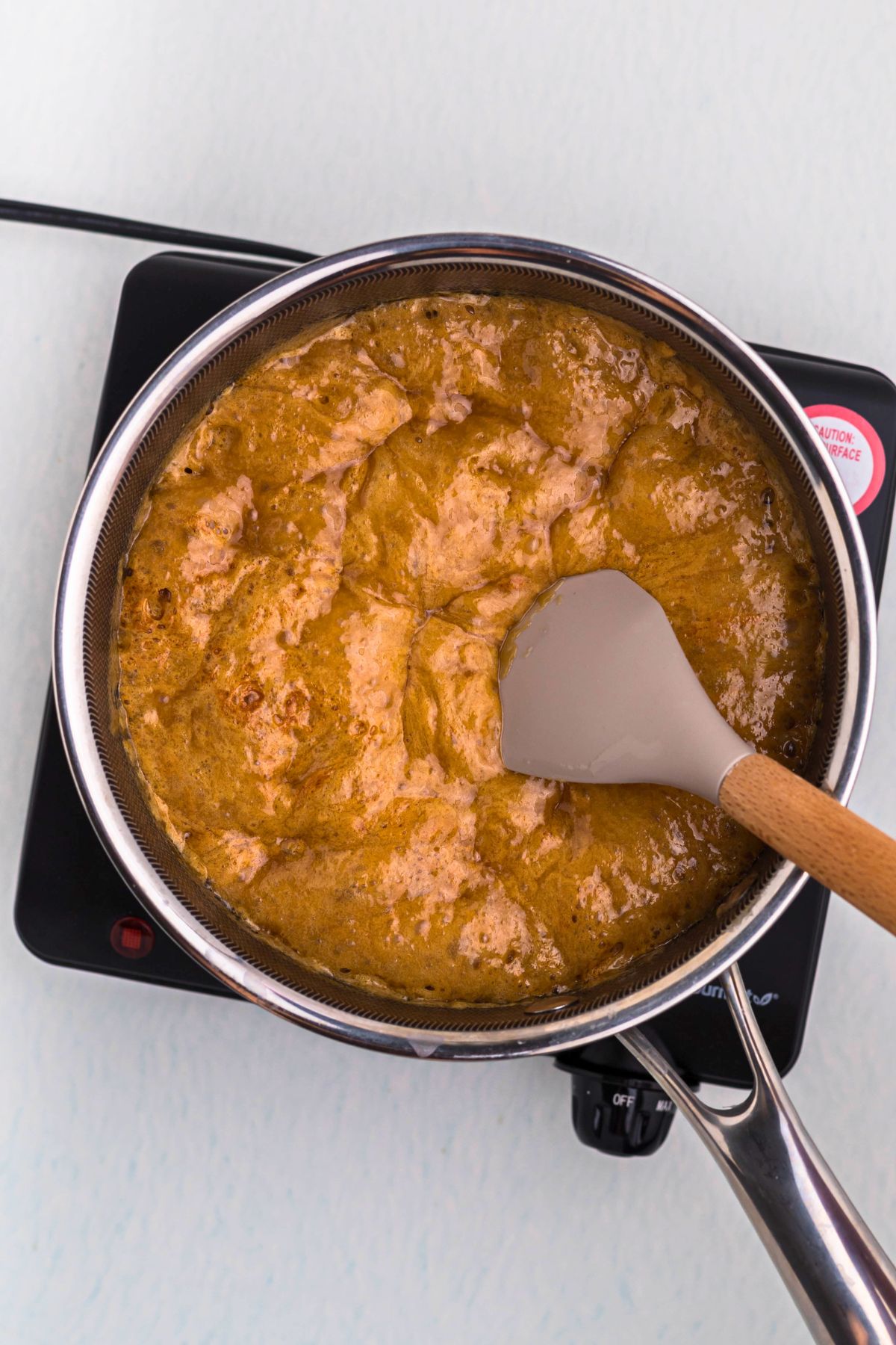 Caramel mixture boiling and puffing up after adding baking soda.