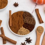 Spices measured out into small bowl on a marble table.