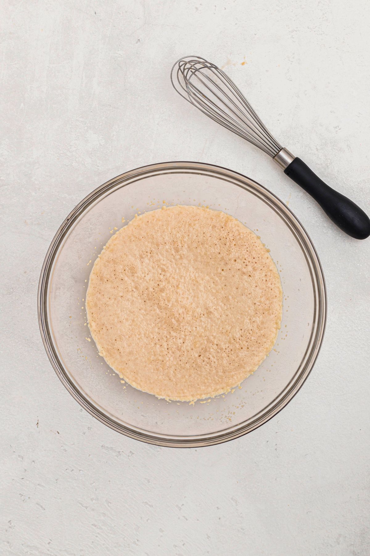 Yeast in a clear glass bowl, that had mixed with warm milk and sugar, until it blooms in the bowl.