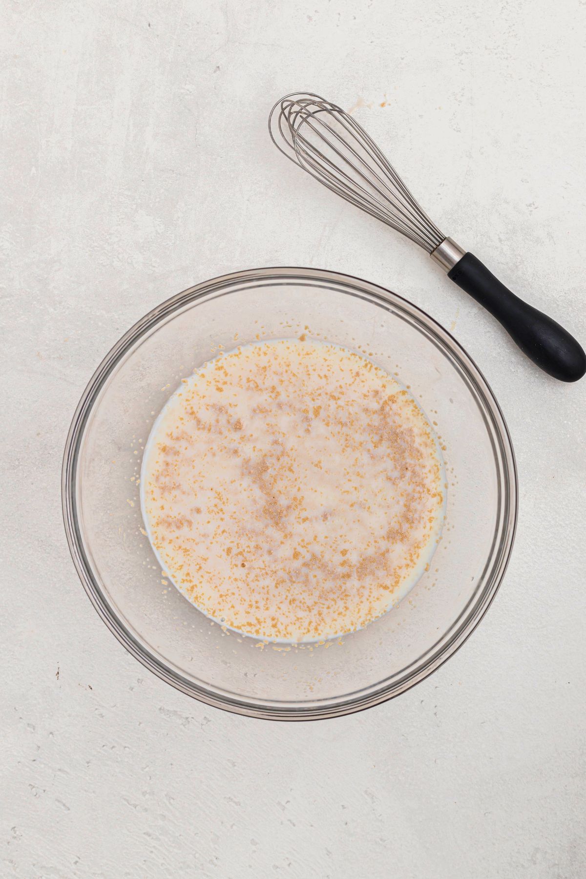 Yeast in a clear glass bowl, mixed with warm milk and sugar. 
