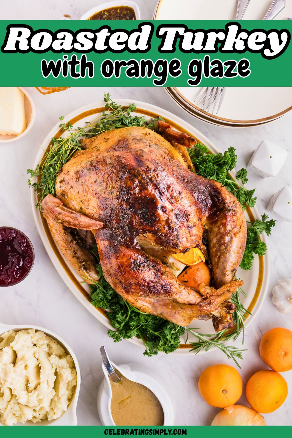 Plated roasted turkey on a serving platter, surrounded by plates, honey, and other food, on a white marble table.