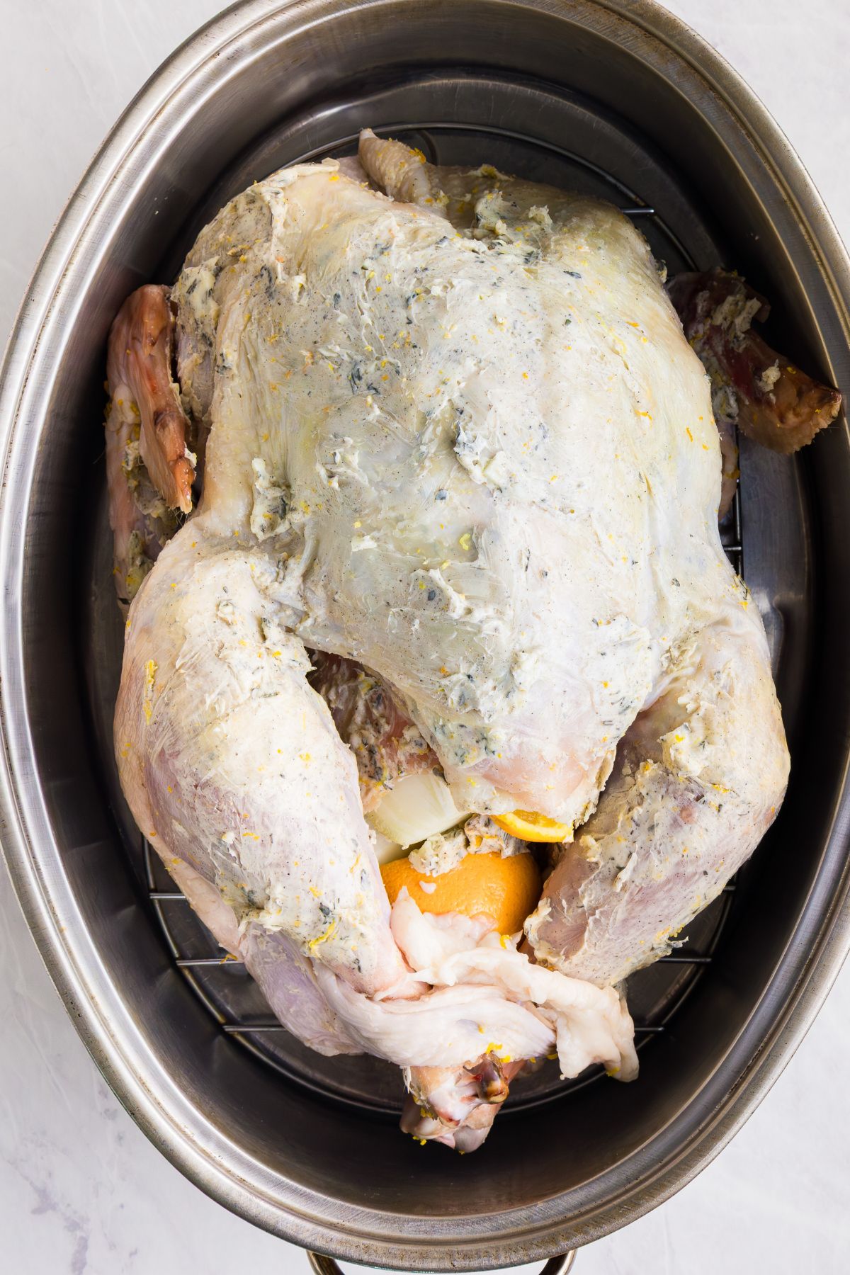 Whole uncooked turkey, seasoned, in a large roasting pan. 