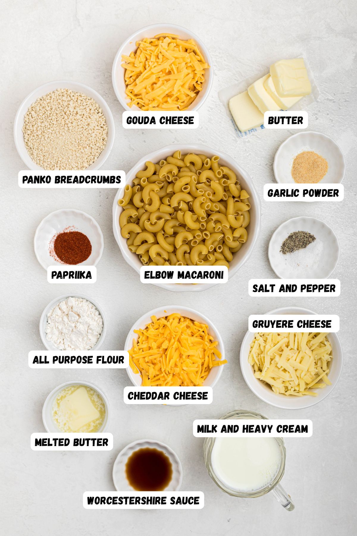 Ingredients measured into small bowls on a white marble table with labels over each bowl. 