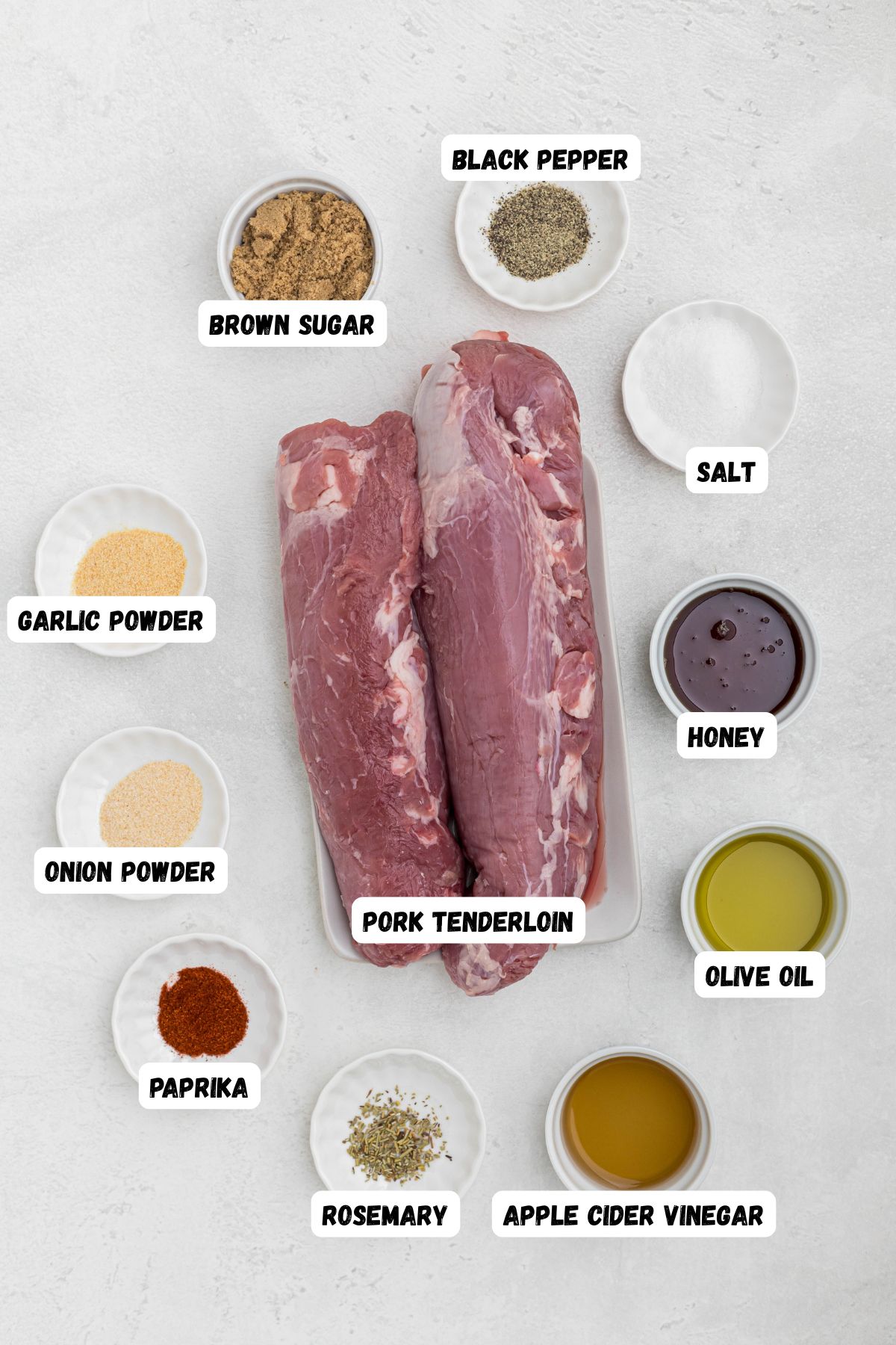 ingredients measured into small bowl and labeled, on a white marble table. 