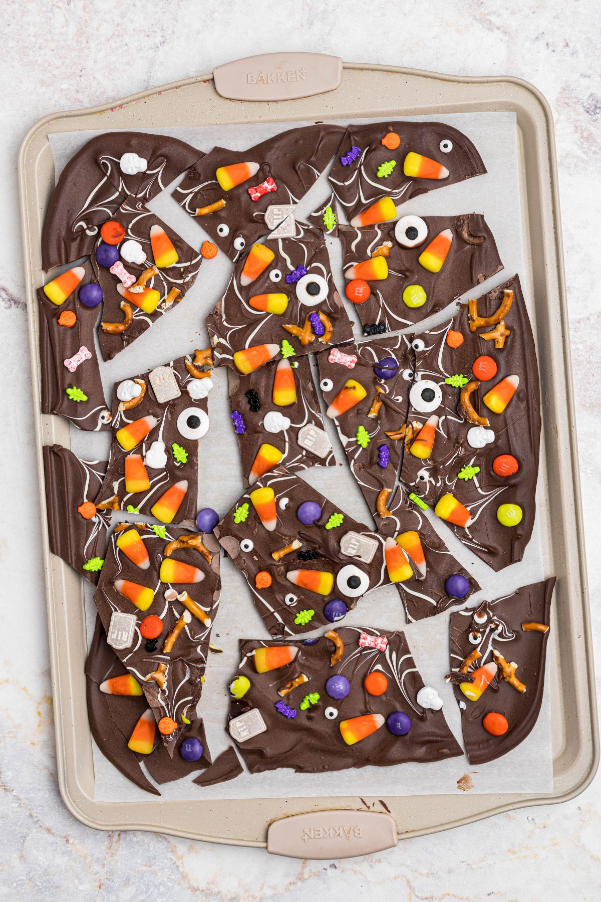 Layer of chocolate that had been melted and spread out, then has added toppings, and chilled until set, broken into smaller pieces for serving. 