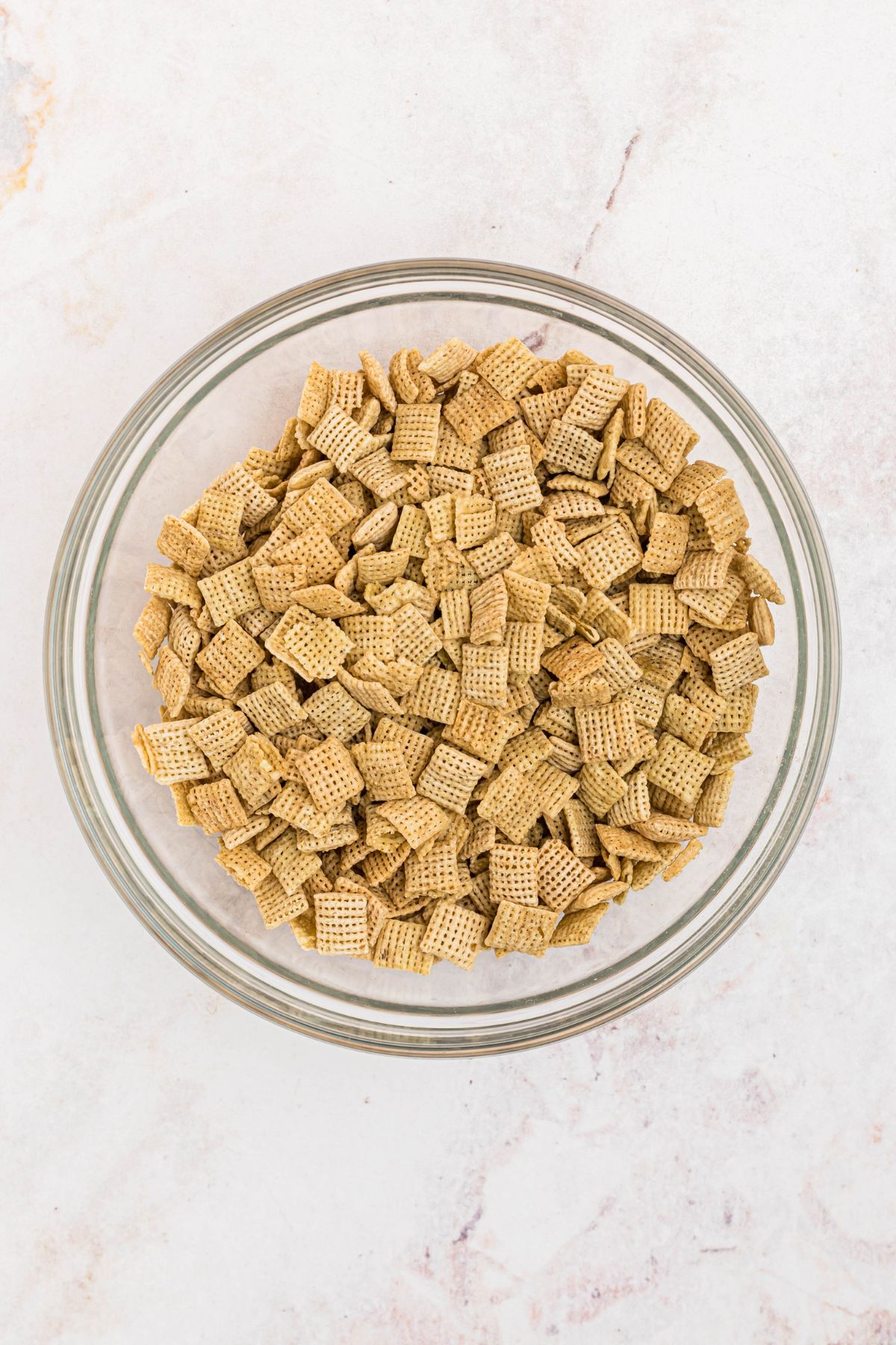 Large mixing bowl filled with rice Chex cereal. 
