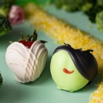 Wicked themed dipped strawberries on a green table with yellow rice for a road.