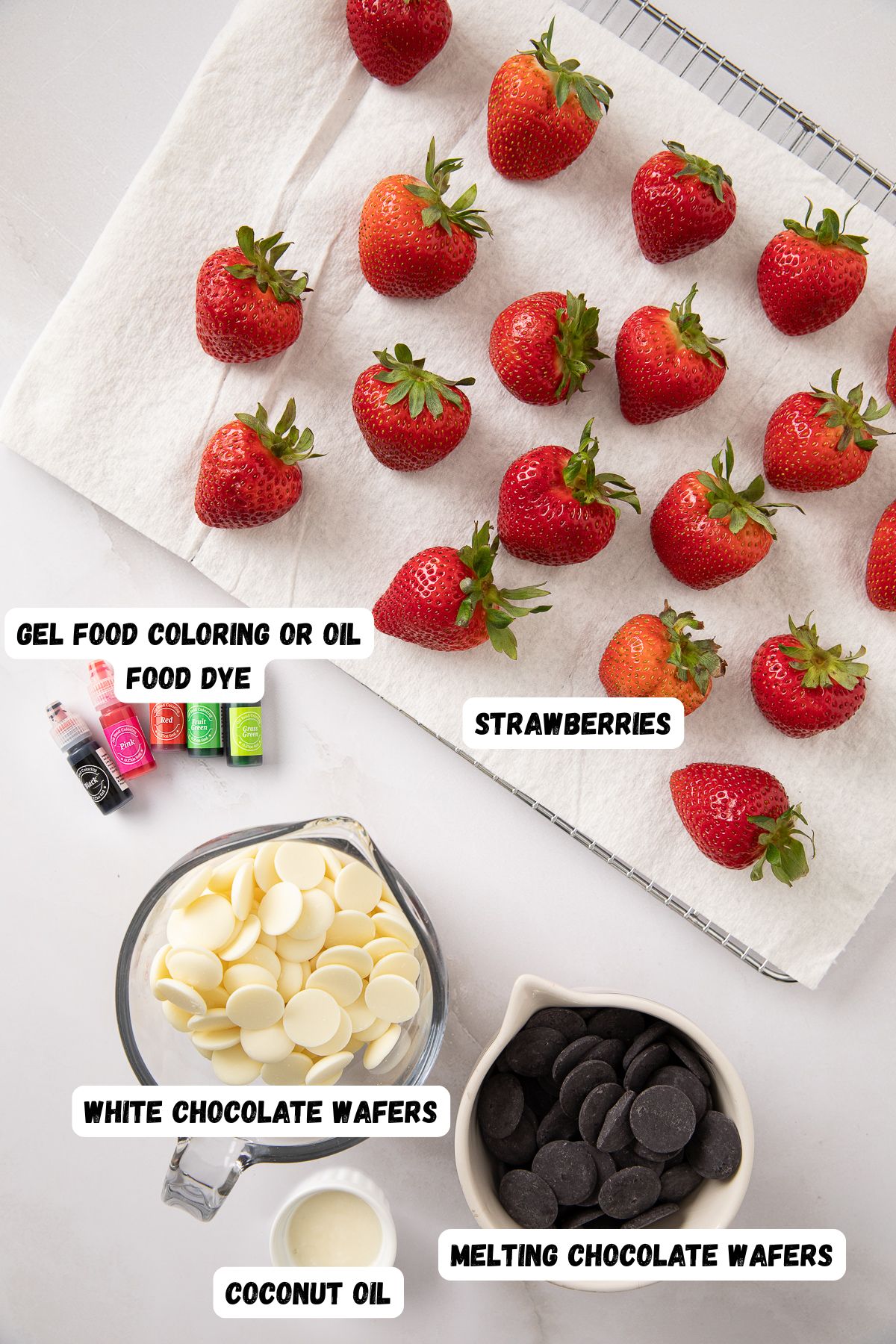 Ingredients needed to make dipped strawberries on a marble table, then labeled. 