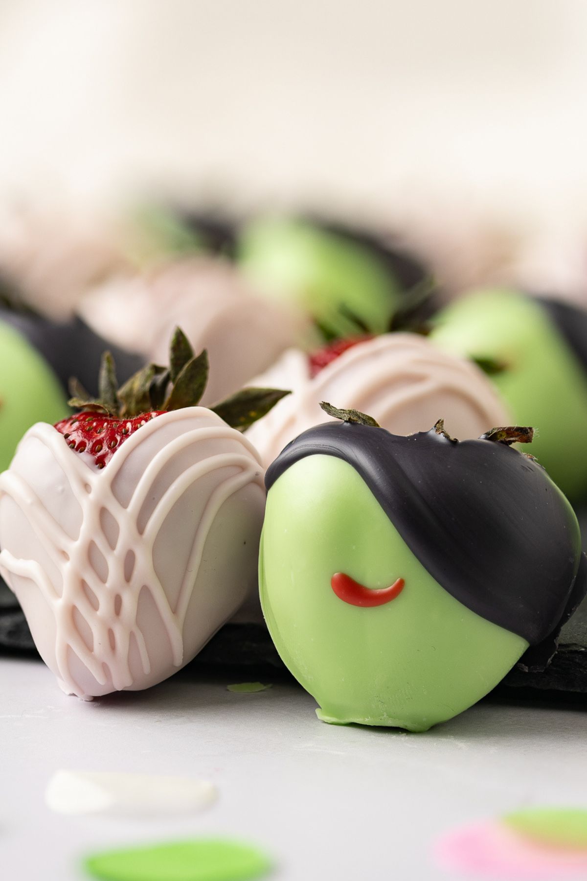 Wicked themed dipped strawberries on a marble table set to dry. 