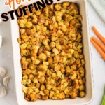 Golden, juicy stuffing in a rectangle container on a table with carrots, celery, and other ingredients around the dish.