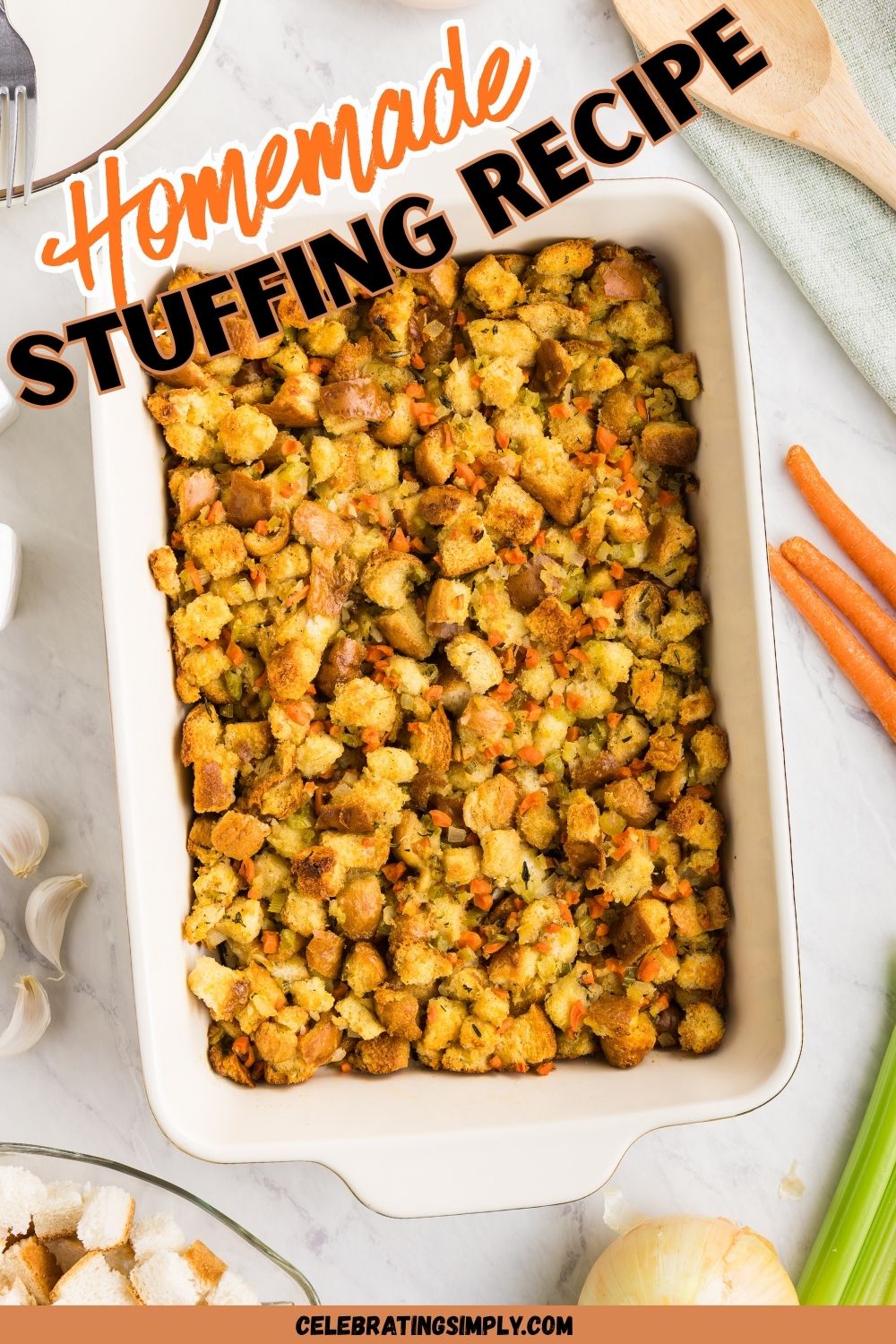 Golden, juicy stuffing in a rectangle container on a table with carrots, celery, and other ingredients around the dish.