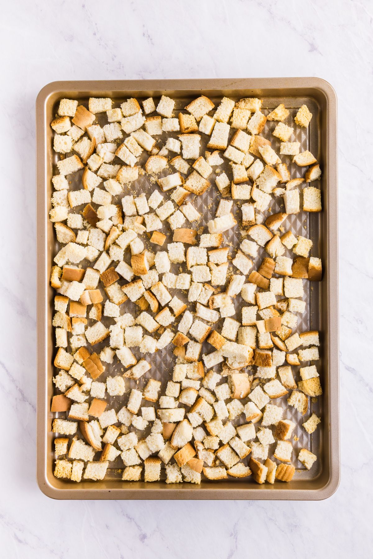 Cooked to golden brown, pieces of bread on a baking sheet.