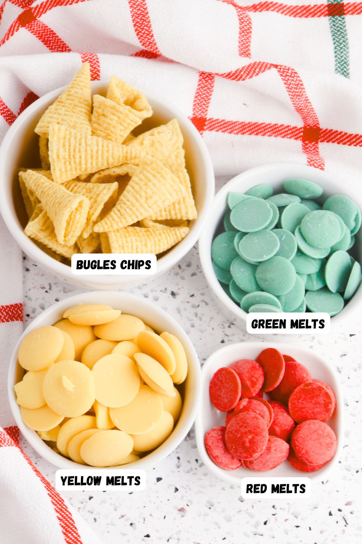 Red, green and yellow melting chocolates with a bowl of corn chip bugles, labeled on a table. 