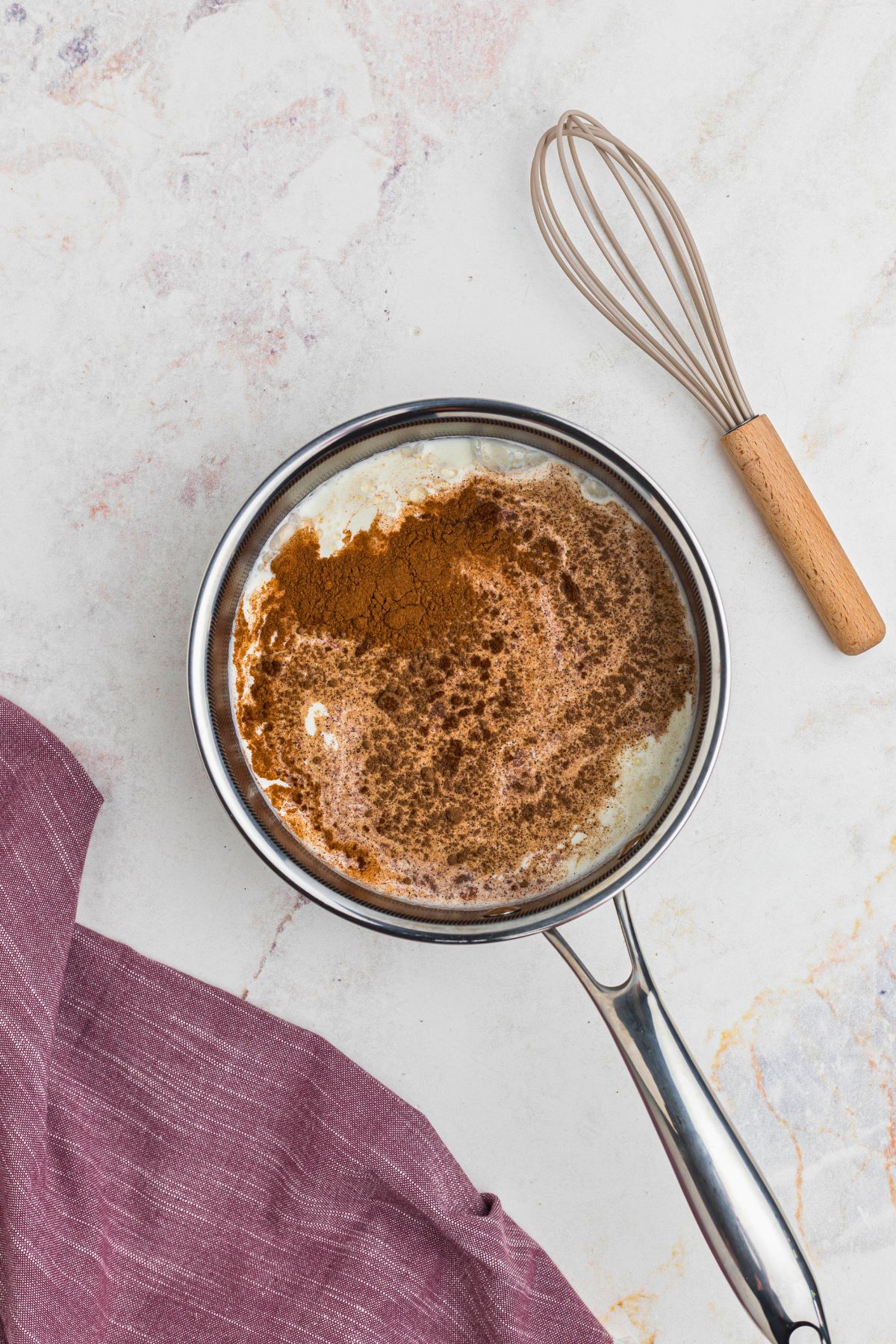 Milk, heavy cream, and seasonings, mixed together in a saucepan.