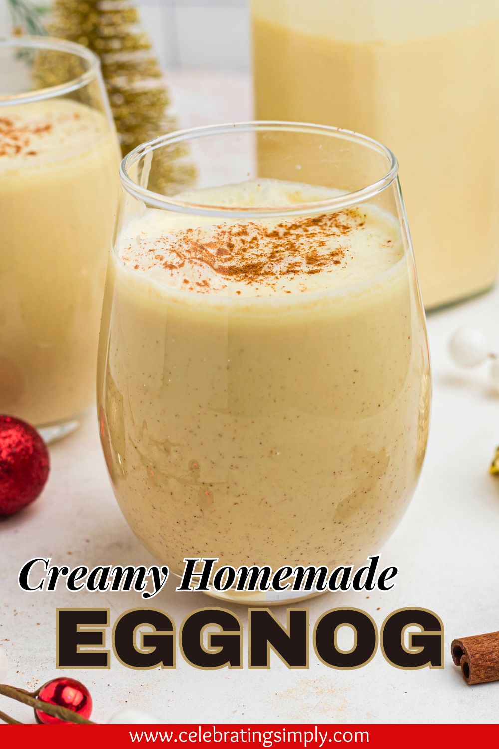 Creamy homemade eggnog in a clear glass bowl surrounded by cinnamon sticks and small Christmas decorations.