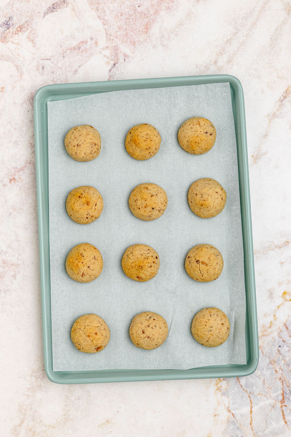 Golden brown baked cookies on a baking sheet.