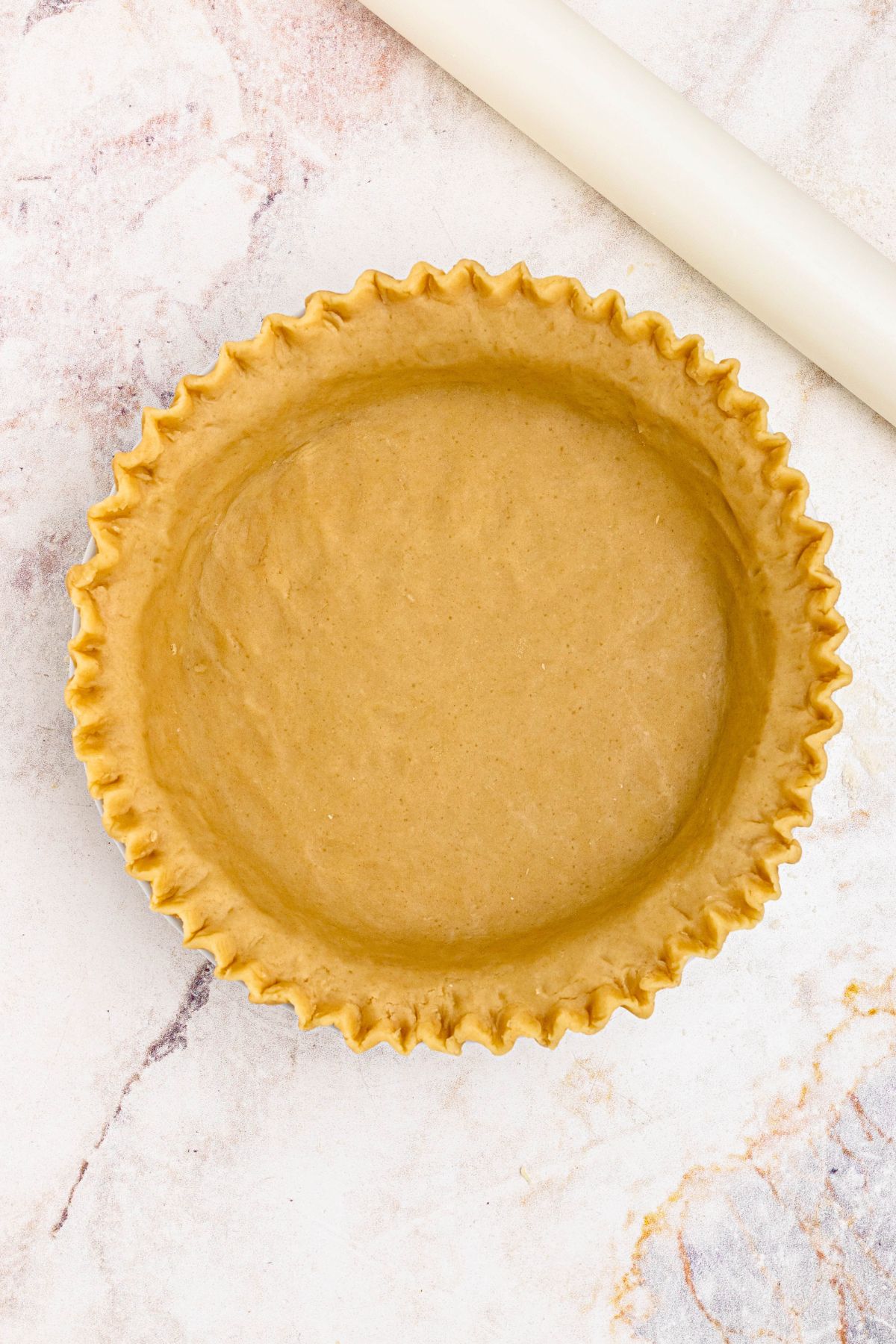 Golden pie crust, rolled into pie plate, with edges fluted. 