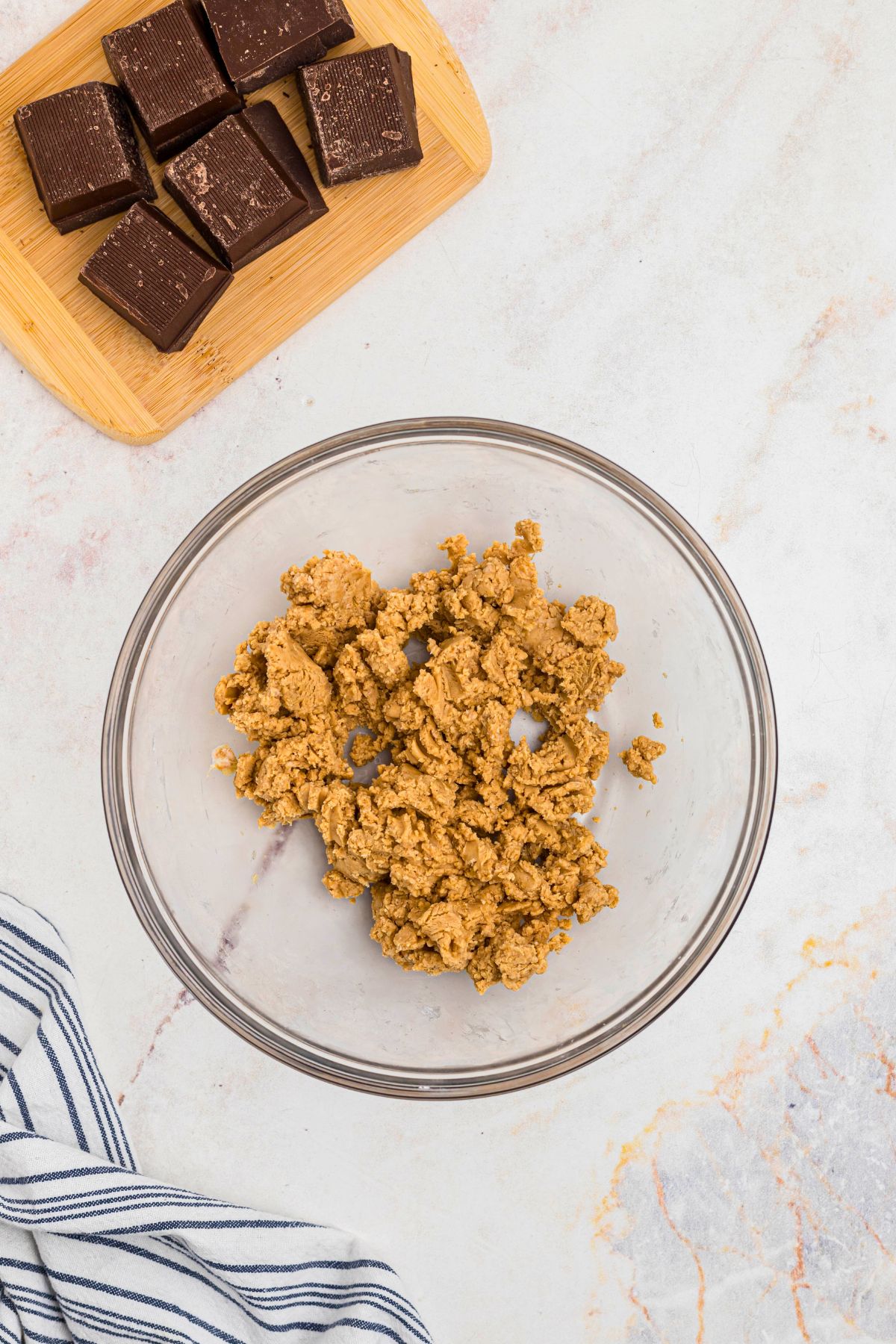 Creamy peanut butter mixed with butter and powdered sugar, in a clear glass bowl. 
