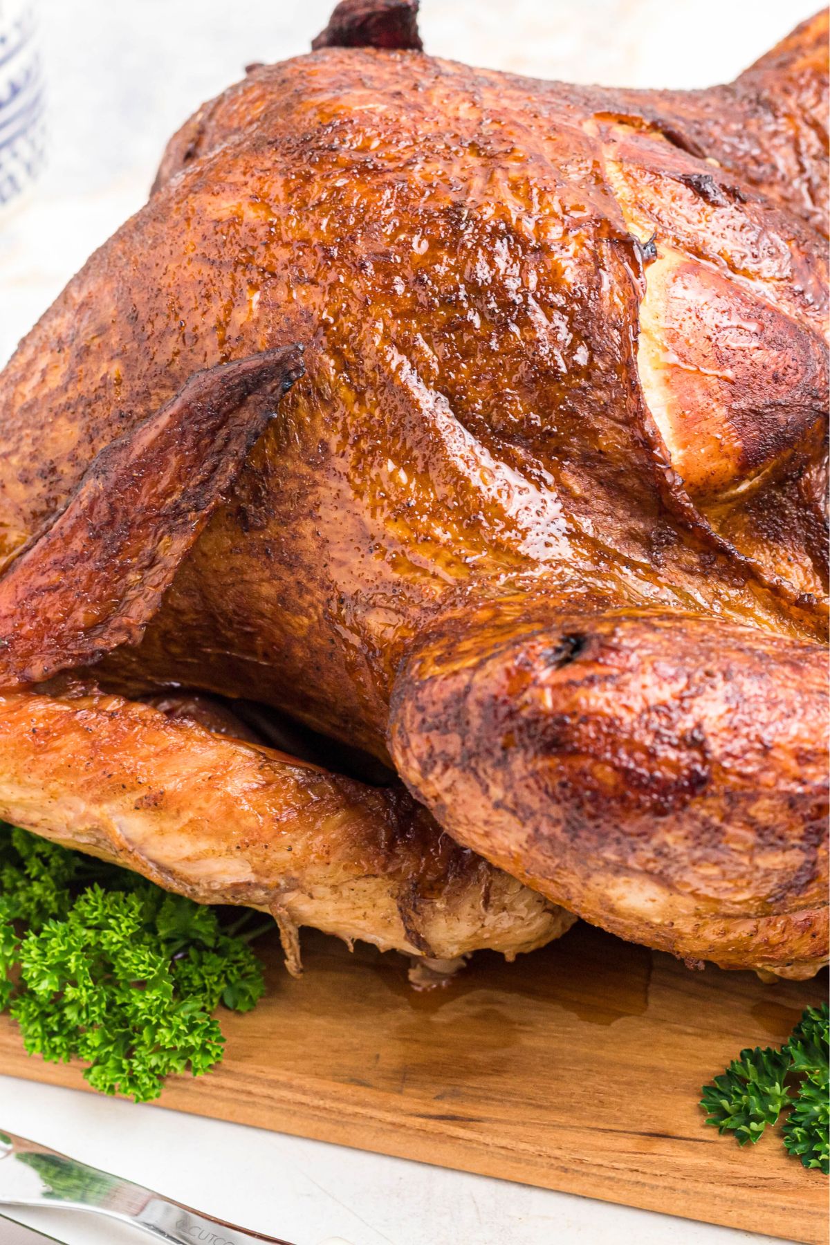 Close up image of smoked turkey on a cutting board, before being cut and served.