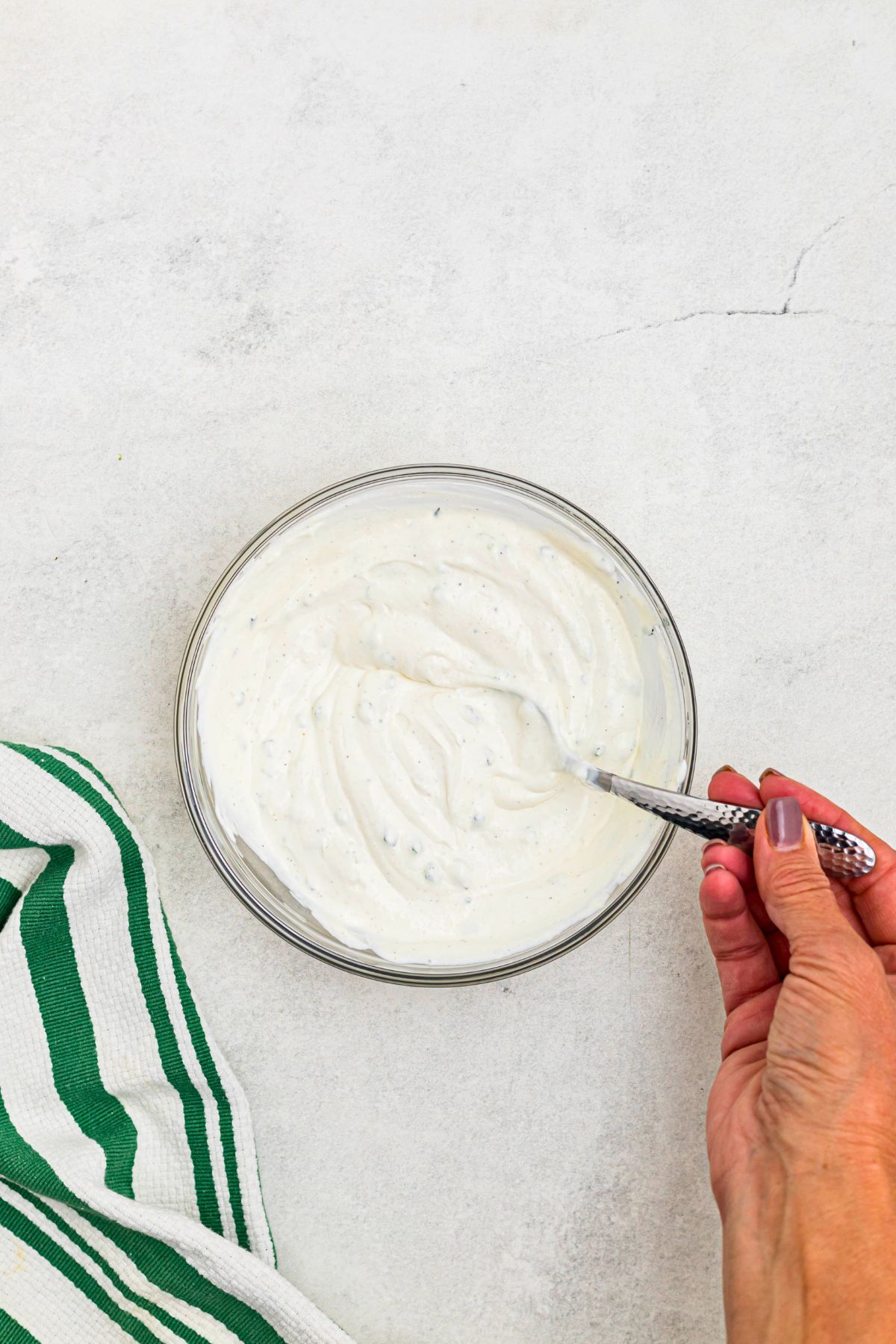 Sour cream dip in a clear glass bowl after being mixed together. 